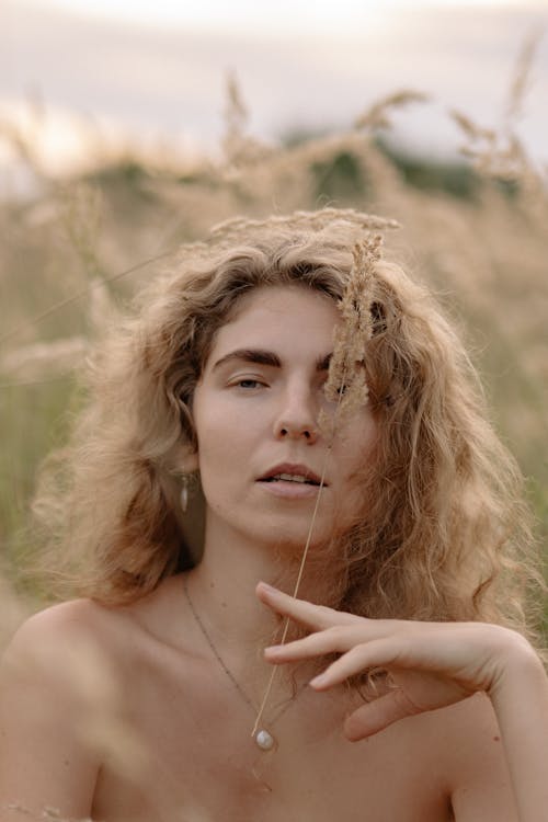 A Woman With Blonde Hair Holding a Dried Grass