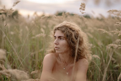 Nude Woman Covered by Grass Posing on a Field 