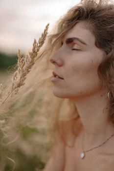 草地上，一位闭着眼睛的女人正在拥抱自然，这是一张特写肖像