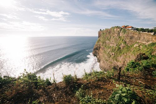 Free Breathtaking view of a sunlit ocean and cliffside with lush greenery. Perfect for nature lovers. Stock Photo