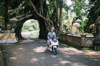 Man in Blue Jacket Riding on White and Black Motor Scooter