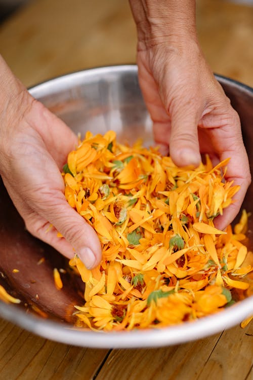 Free Hands Mixing Flower Petals in Bowl Stock Photo