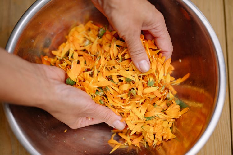 Woman Mixing Flower Petals In Bowl