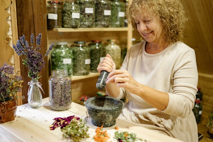 Smiling Florist Sitting And Working With Flowers