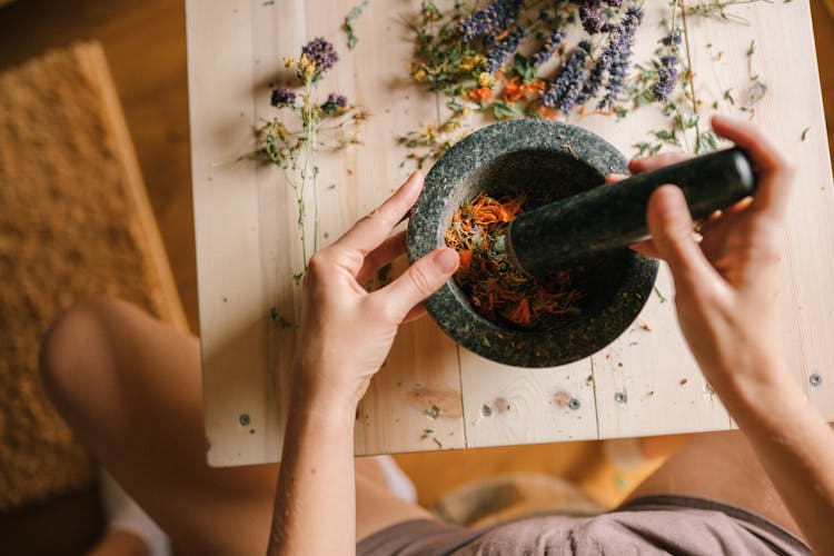  A Person Using A Mortar And Pestle