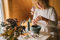 A Woman in White Dress Ponding Dried Flowers