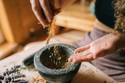 Free A Person  Mixing Herbs by Hand  in the Mortar Stock Photo