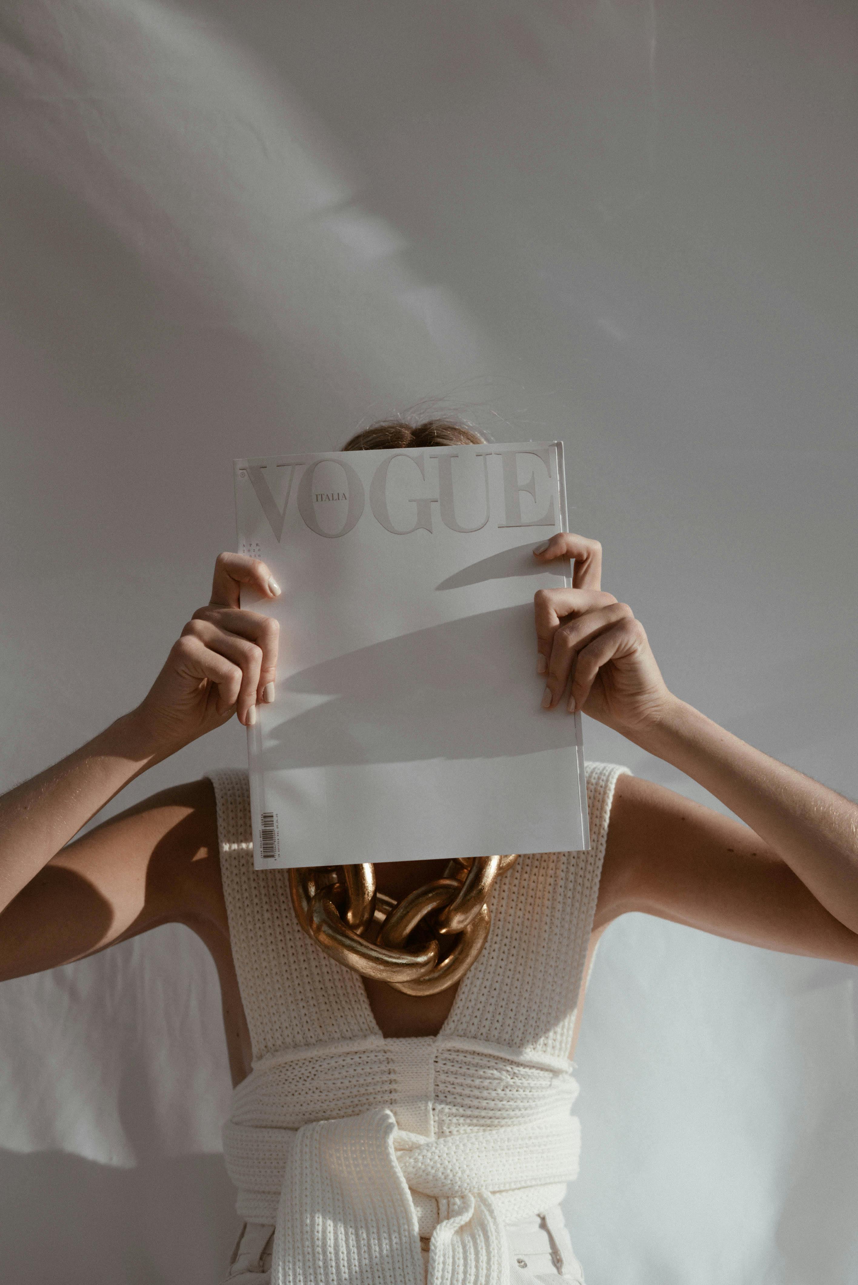 Anonymous woman covering face with magazine · Free Stock Photo