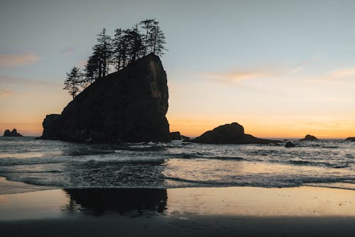 日没時の海の岩の崖