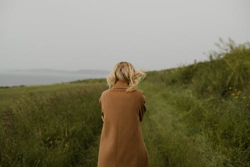 Free Anonymous woman walking in cold field Stock Photo