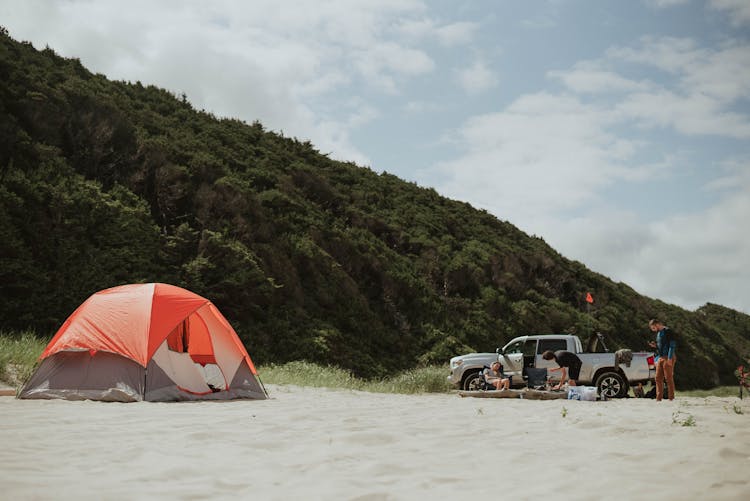 Campers And Tent On Sandy Beach