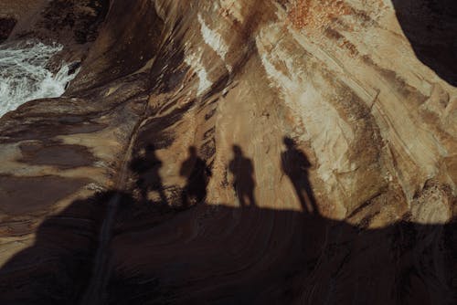People silhouette on high cliff
