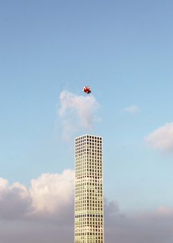 一座摩天大楼引人注目地伸向天空，五颜六色的气球在宁静的背景中漂浮