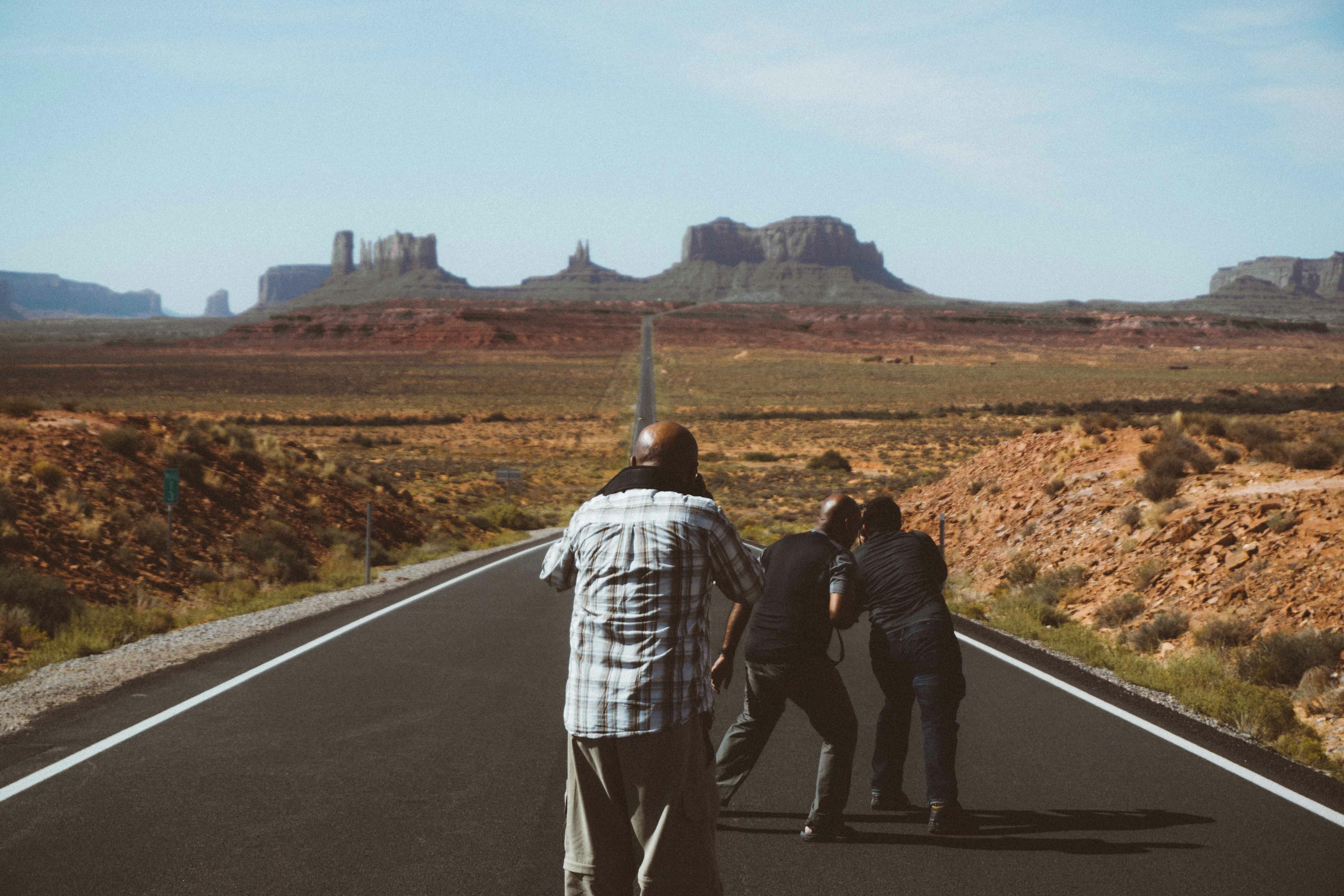 unrecognizable black men on asphalt road