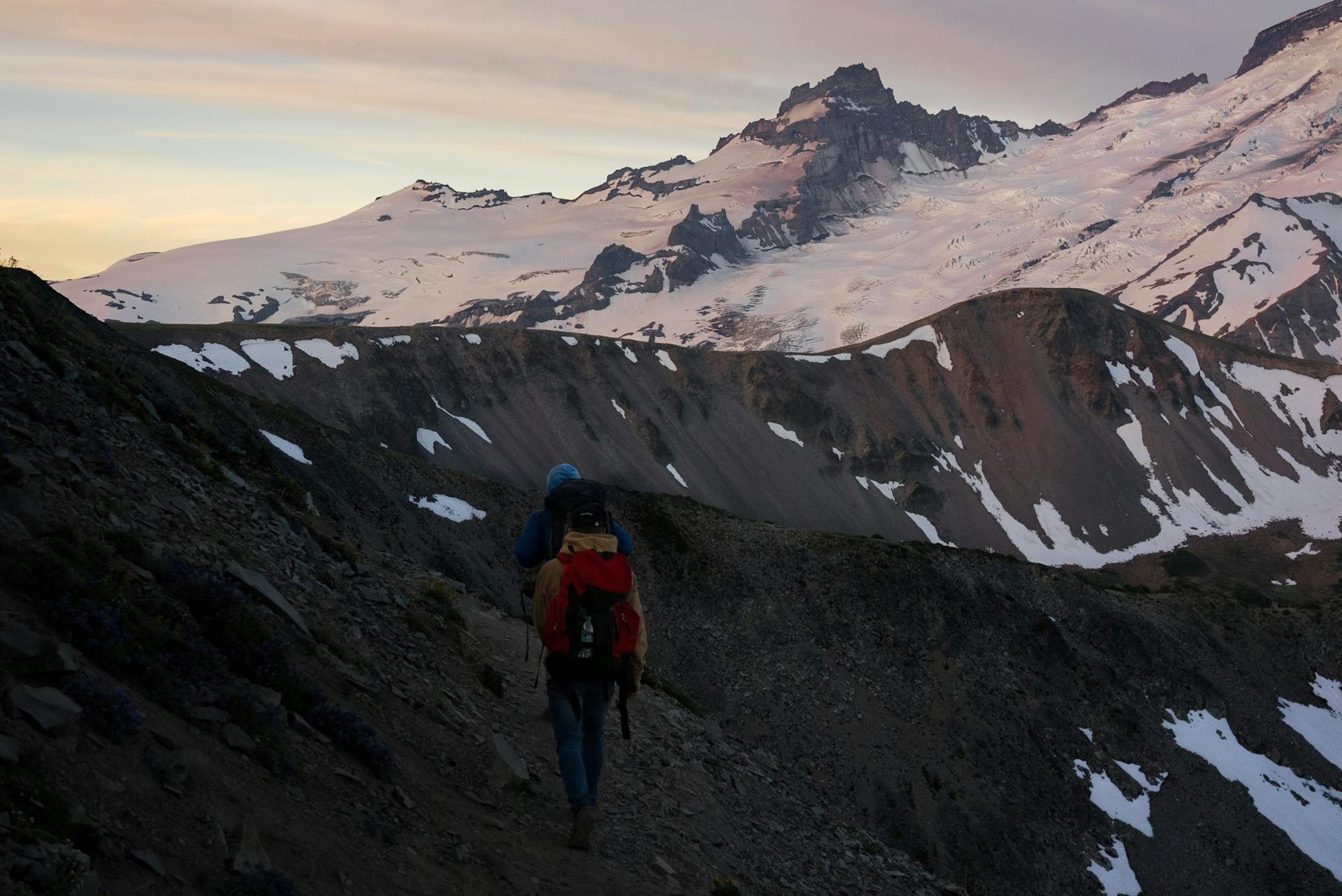 Unrecognizable travelers walking on slope of mountain