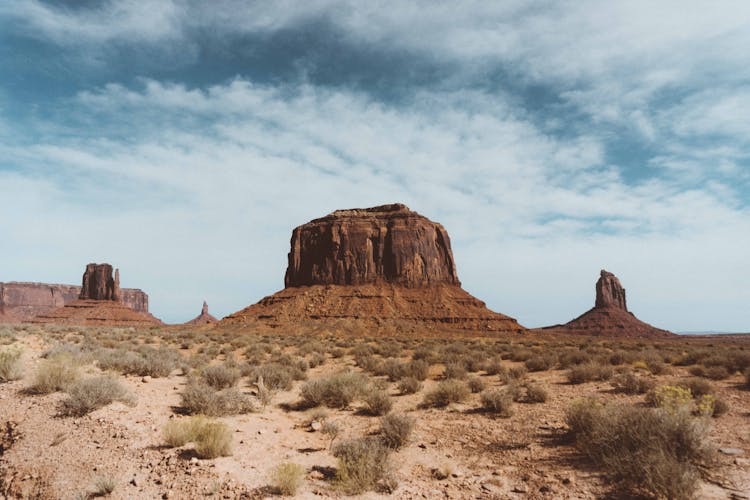 Rocky Formations In Desert With Bushes