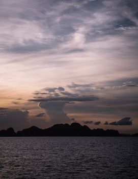 黄昏时分，美丽的海景与山脉的剪影以及戏剧性的云层交相辉映