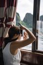 女人从船窗用相机捕捉自然风光