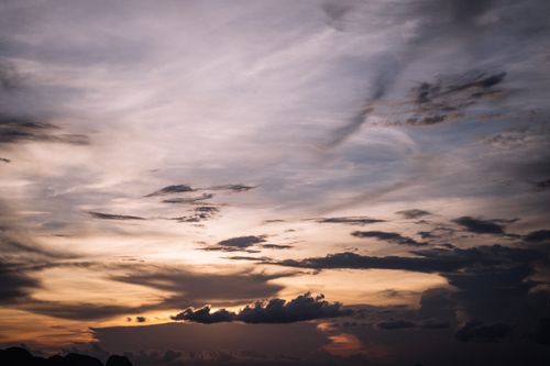 Free Dramatic sky at dusk with swirling clouds and soft sunset tones, creating a moody atmosphere. Stock Photo