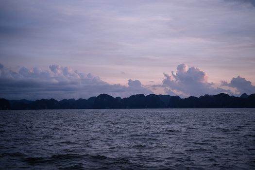 下龙湾暮色宁静，海面平静，越南的云层戏剧般变幻