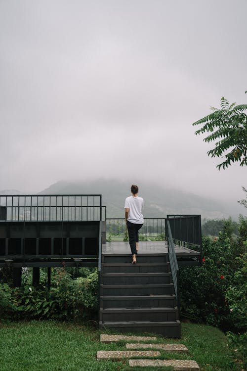 A Person in White Shirt Walking on a Staircase