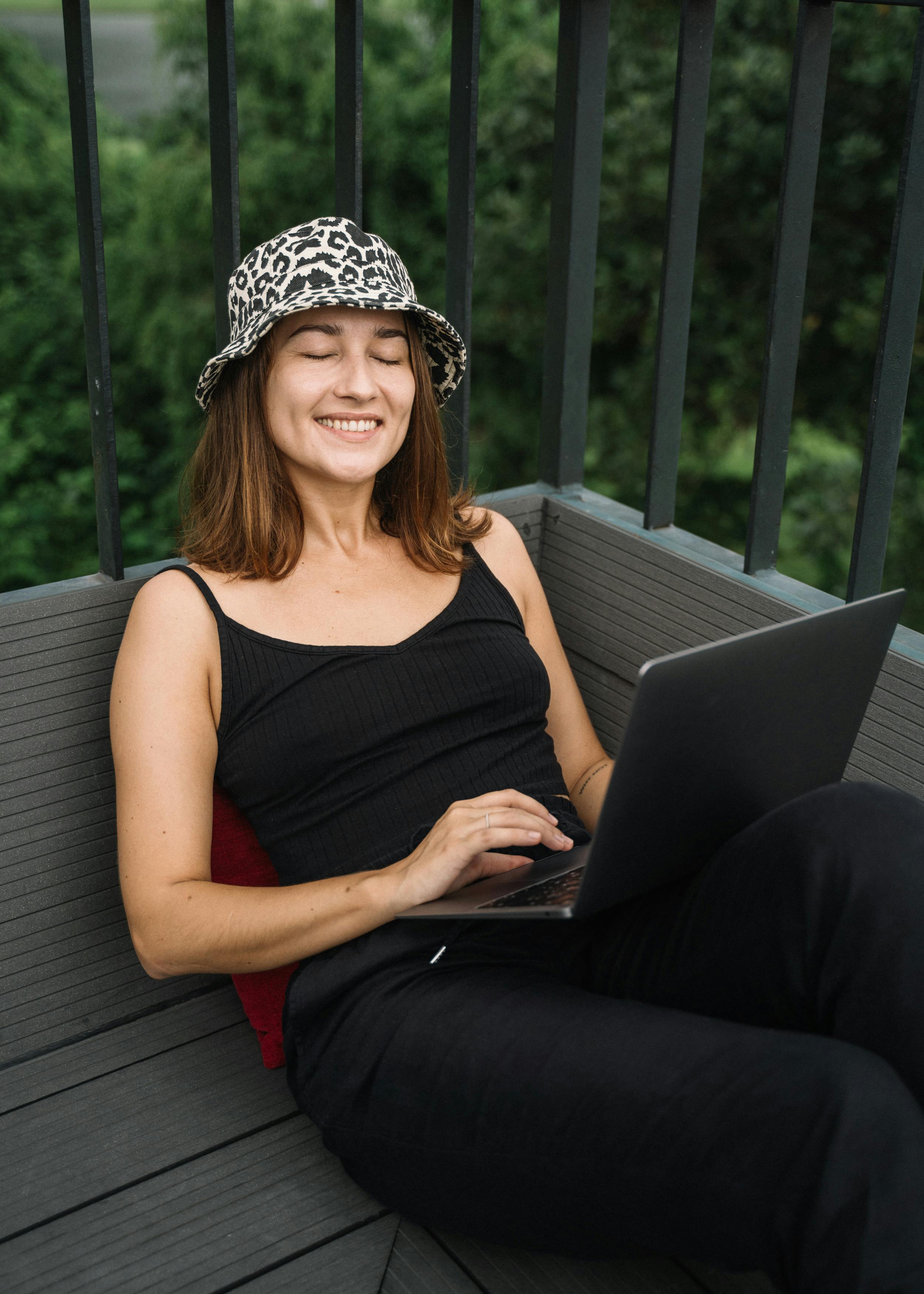 woman in black tank top using a laptop