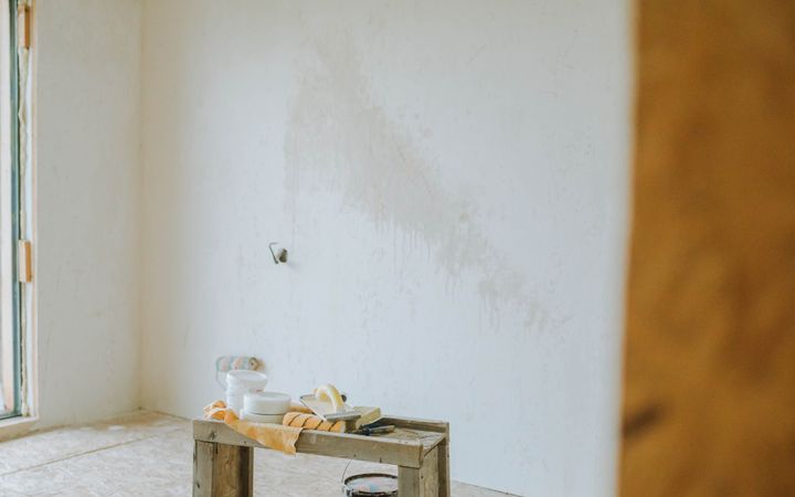 A serene room setup with paint cans and wooden crate suggests a work-in-progress renovation.