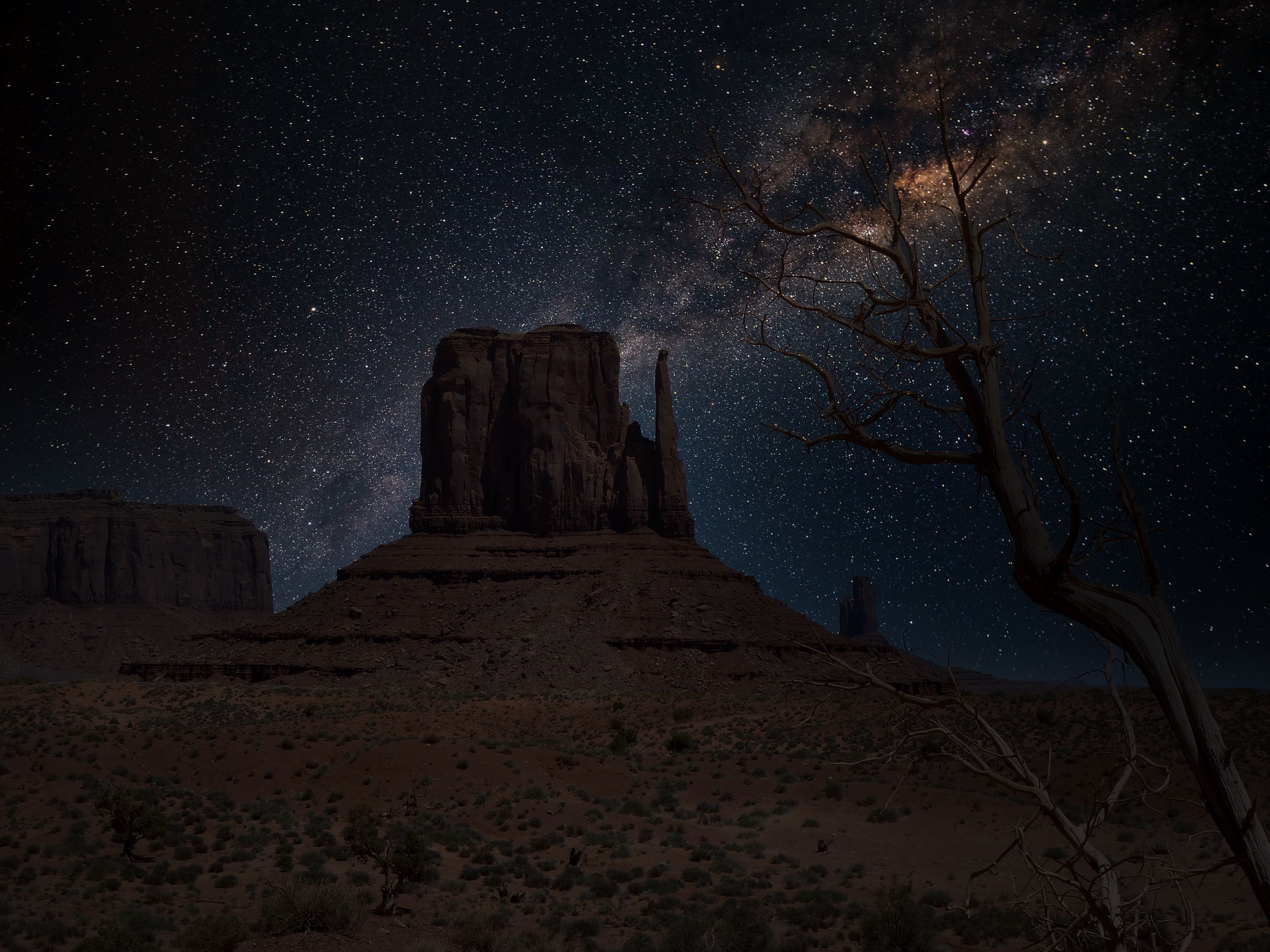 夜晚，纪念碑谷的壮丽景色之上，银河与星空清晰可见