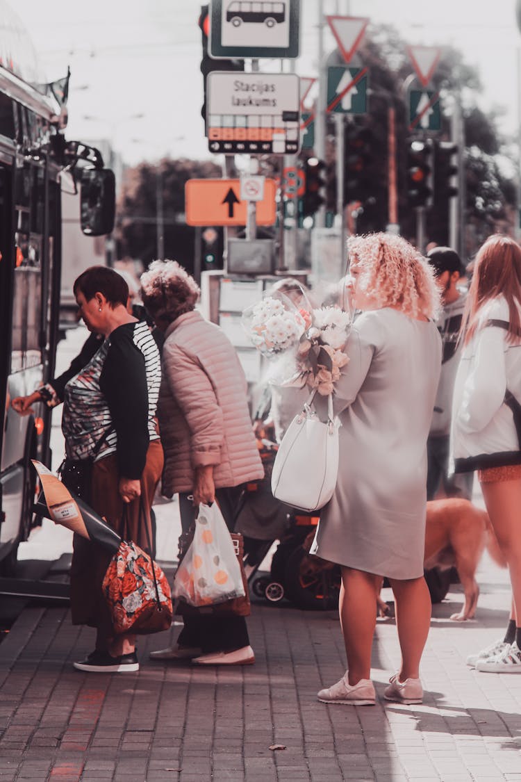 People Boarding The Bus In The Bus Stop