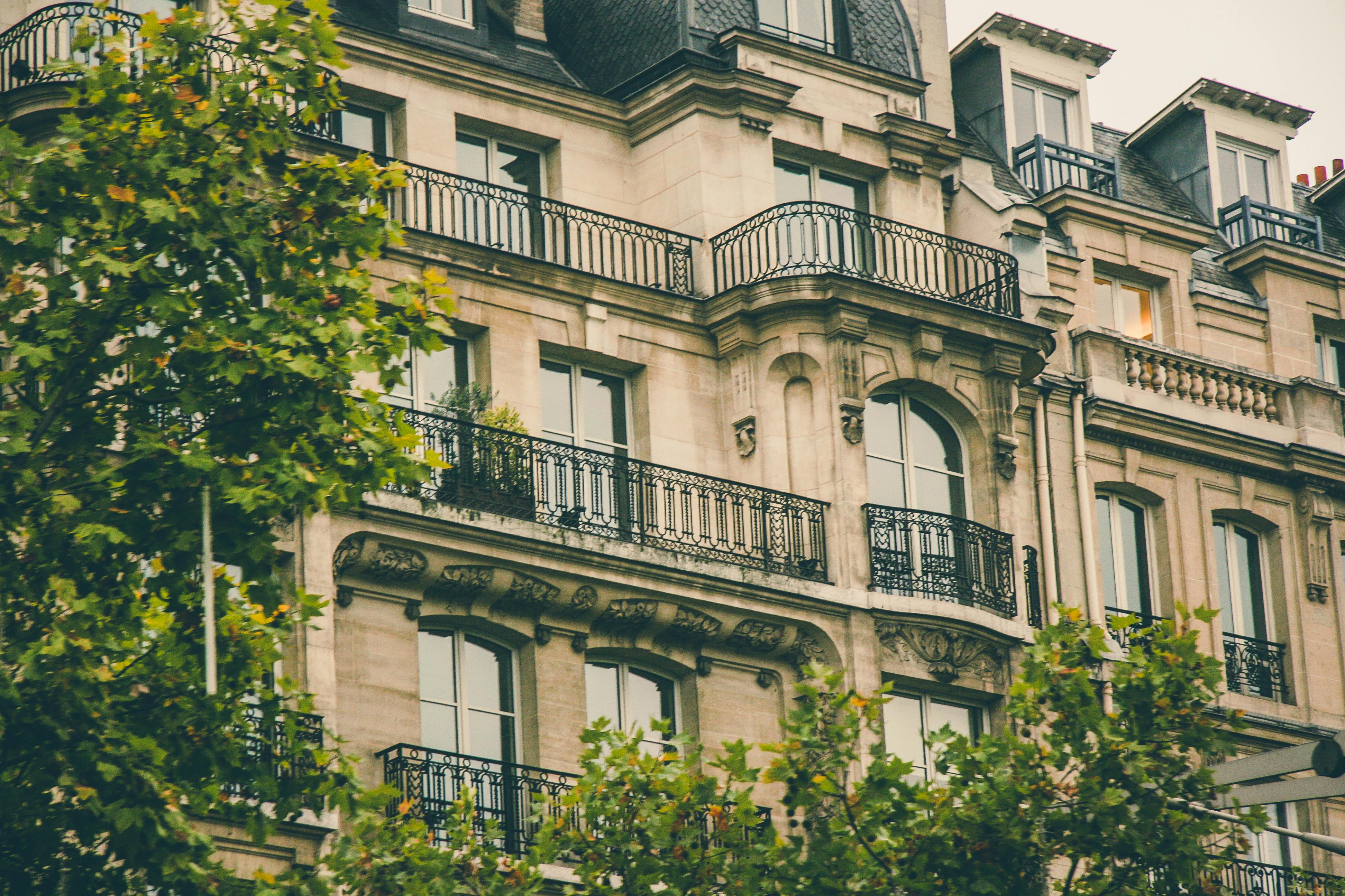 Charming Parisian building facade with ornate balconies and classic architecture.