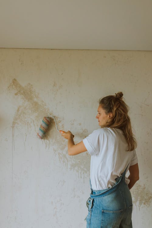Woman in White T-shirt Holding Paint Roller