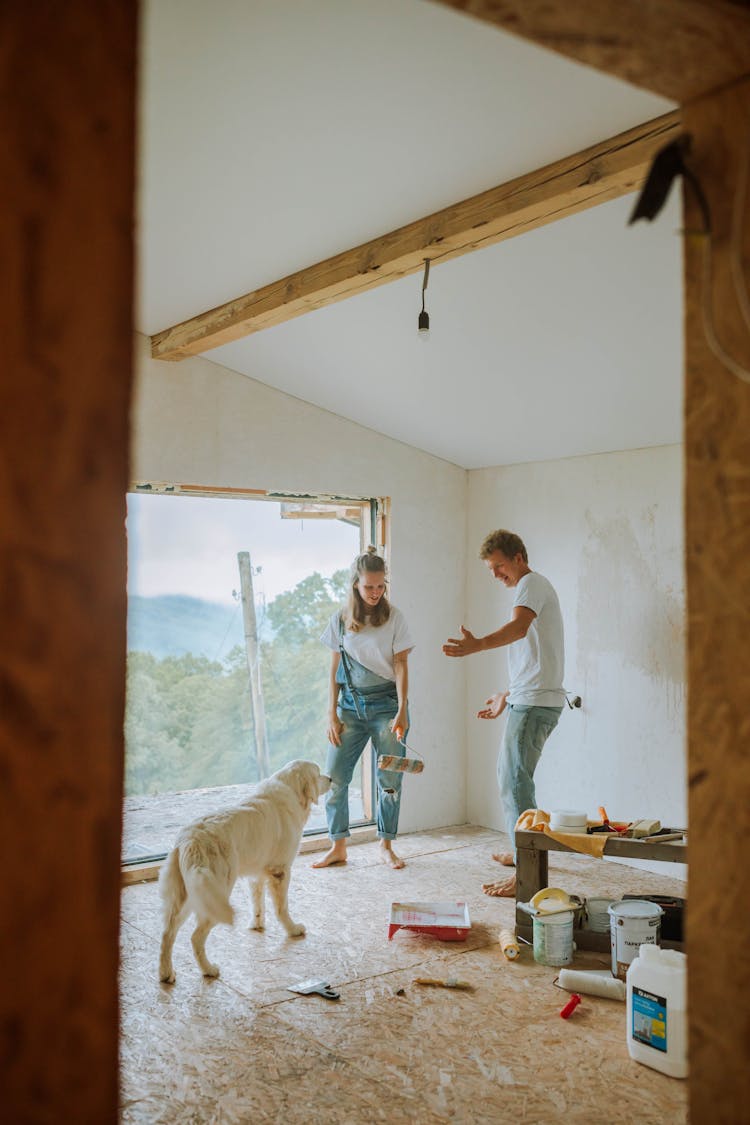 Couple With Dog In House Under Renovation