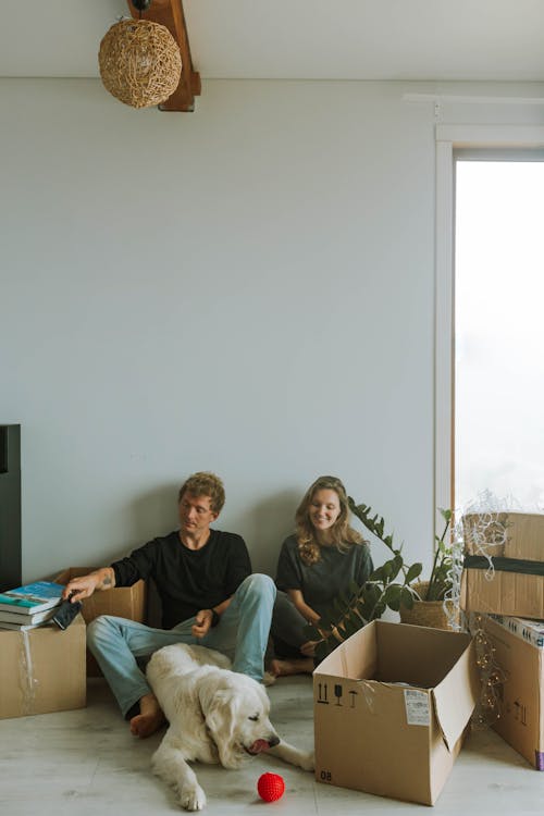 A Couple Sitting Beside the Boxes