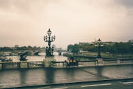 巴黎亚历山大三世桥的朦胧景色中，雕像与塞纳河若隐若现