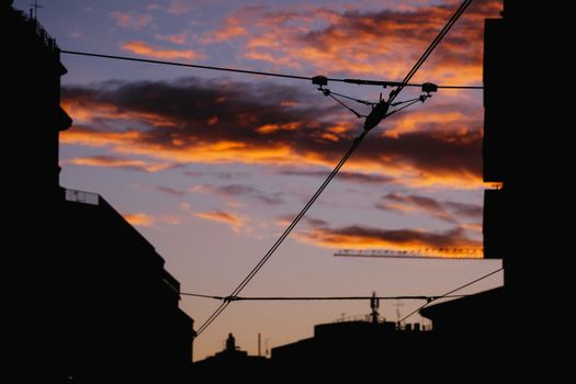 Electrified rails against vibrant sunset in city