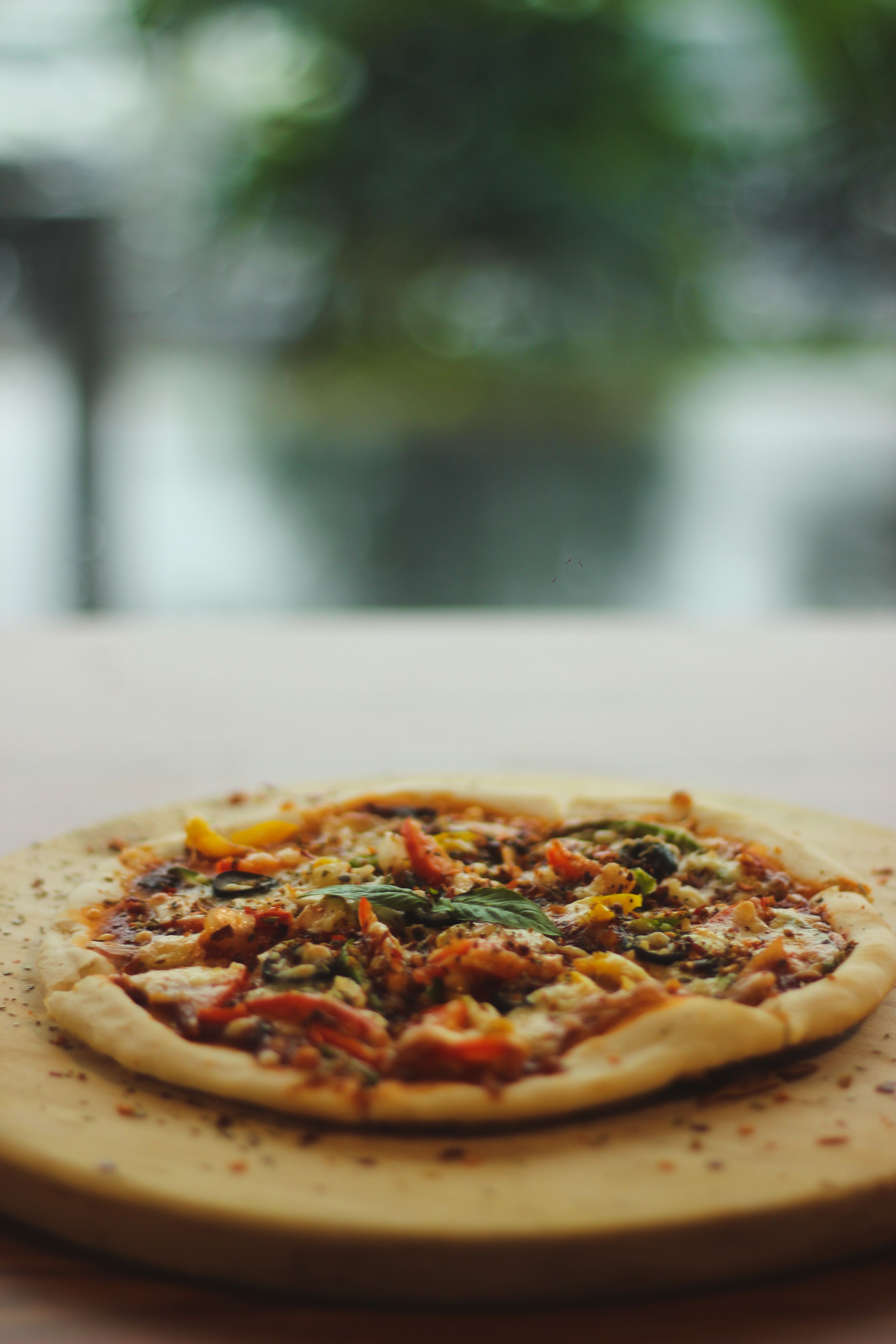 A mouthwatering vegetarian pizza topped with fresh ingredients on a wooden board.