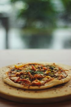 A mouthwatering vegetarian pizza topped with fresh ingredients on a wooden board.