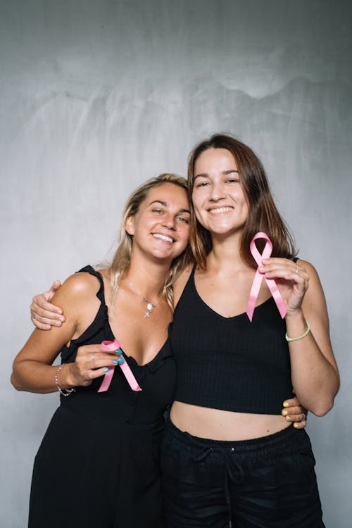 2 Femmes Souriantes Tout En Tenant Des Rubans Roses