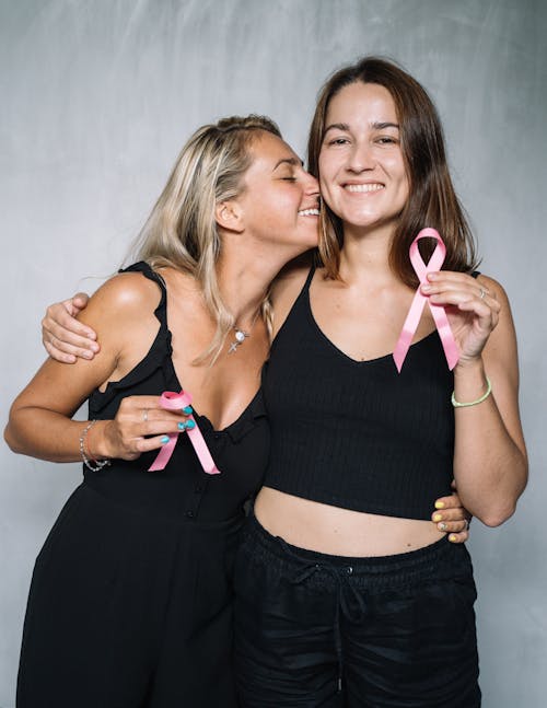 grátis Duas Mulheres De Blusa Preta Segurando Uma Fita Rosa Foto profissional