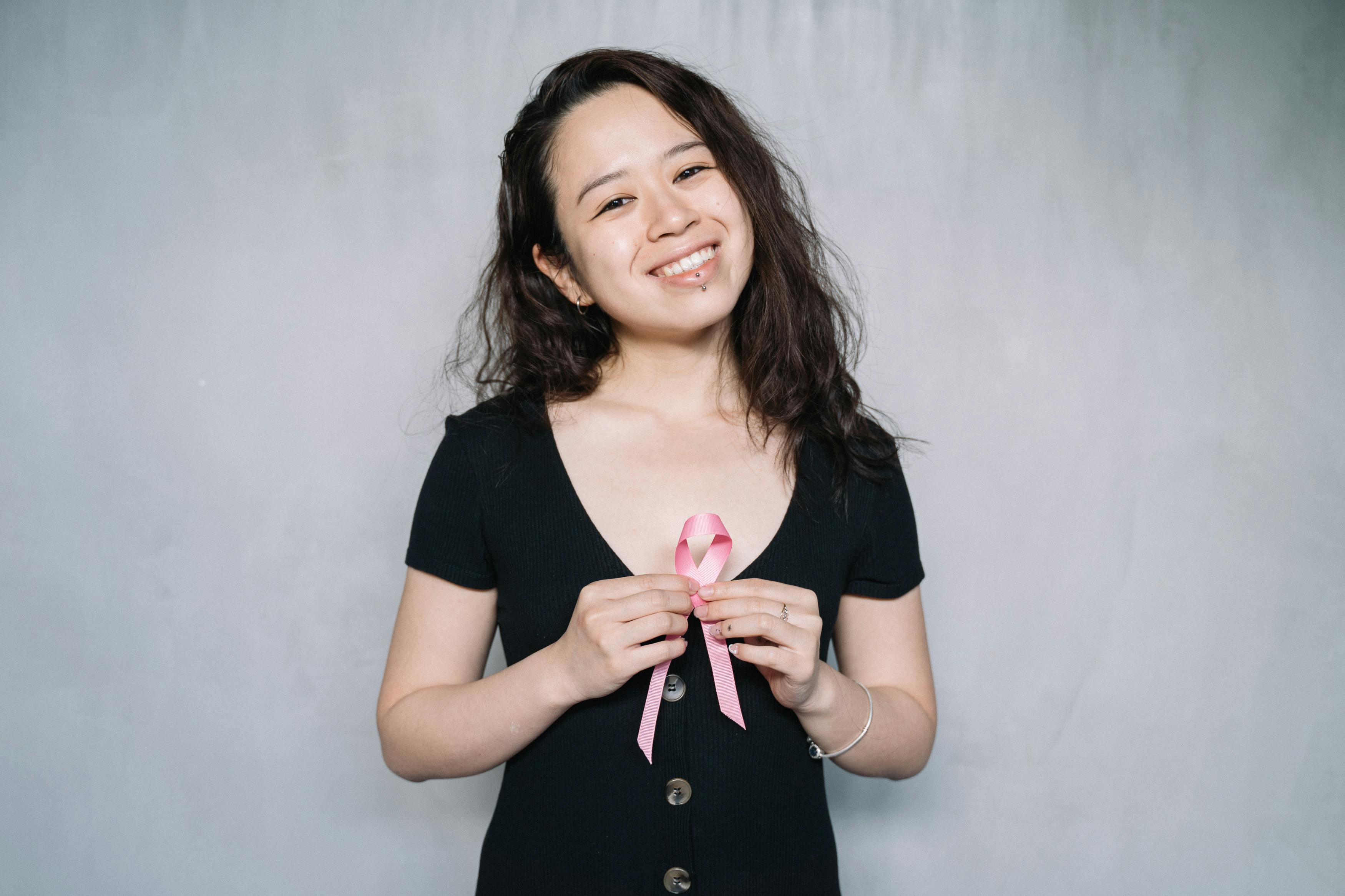 woman holding pink ribbon