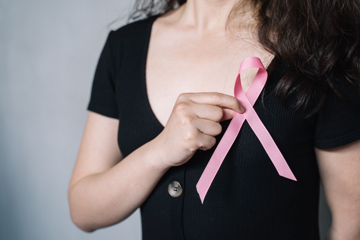 Woman holding a pink breast cancer awareness ribbon