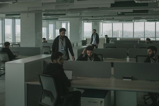 A surreal scene of one man cloned multiple times in an office setting, symbolizing teamwork and multitasking.