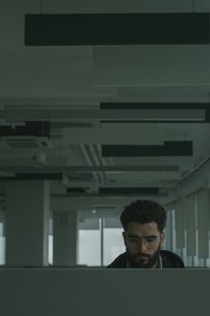 在现代办公环境中，戴着眼镜的软件工程师专注工作，展现了高度的专注力