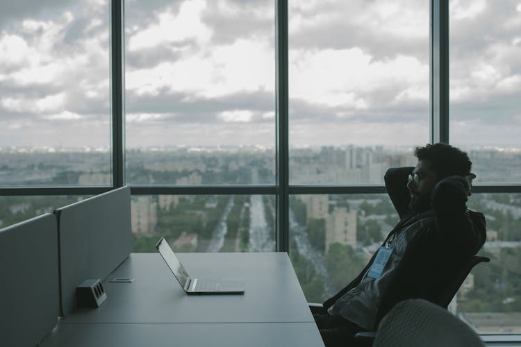 Man Reclining And Looking At His Laptop