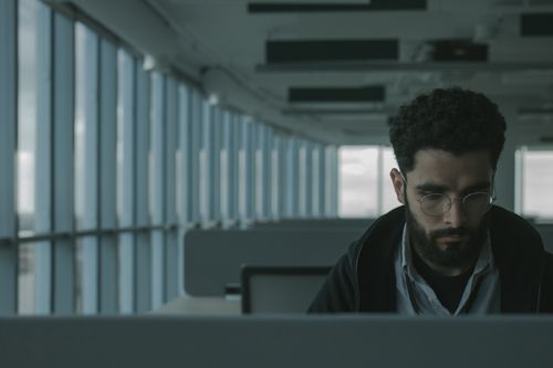 Free Man with glasses and beard working in modern office with large windows. Stock Photo