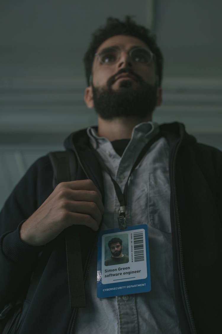 A Man In Black Jacket Wearing His Identification Card