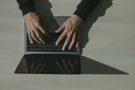 展示技术和互联网使用情况的头顶镜头，拍摄手在笔记本电脑上打字
