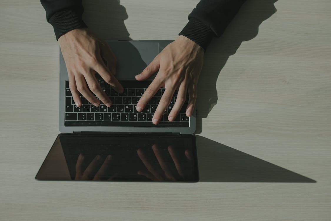 Free Hands Typing on a Laptop Keyboard Stock Photo