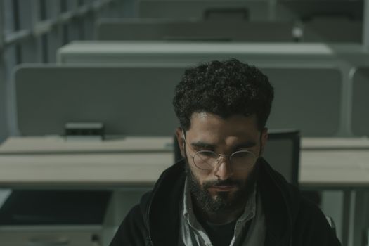 空荡荡的办公室里，一个戴眼镜的人正专心工作