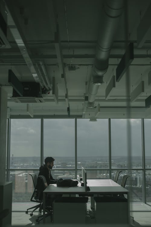 A Man Working with a Laptop Inside an Office